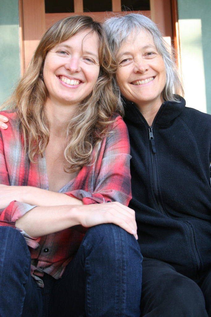 Mother and daughter sitting close on porch