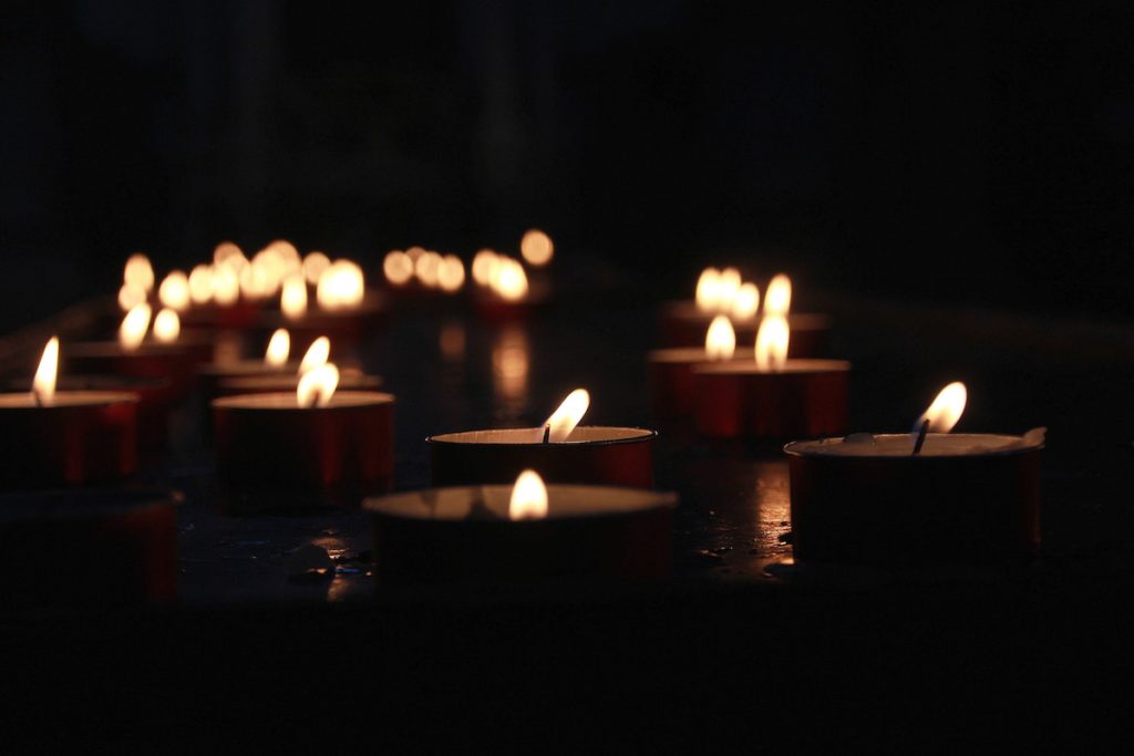 votive candles with flames light the dark 